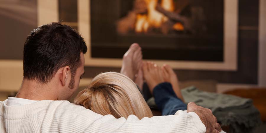 Couple relaxing by a fireplace